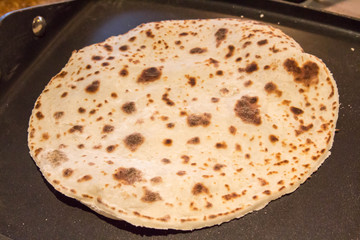 Cooking lefse on a griddle, a Norwegian flat potato bread