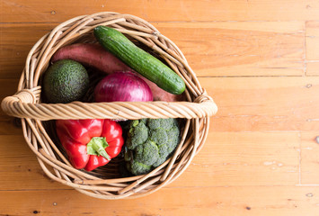 High angle view of vegetables in wicker basket from farmers market with copy space to right (selective focus)