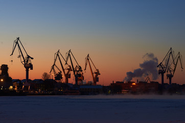 Obraz premium Industrial sea port in winter time. Crane on mornin sky background. Work city landscape. Saint-Petersburg.