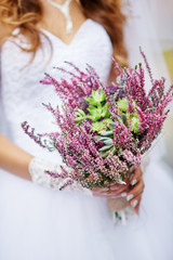 bride holding a beautiful wedding bouquet of wild flowers