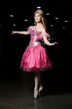 Young woman cosplayer wearing pink dress posing