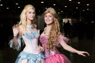 Two young woman cosplayer wearing beautiful dresses posing © Anton Gvozdikov