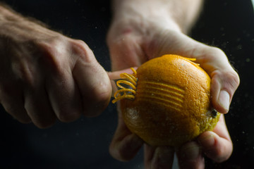 Manos rayando una naranja