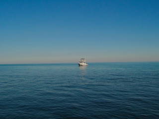 white yacht sails on the sea in the distance on a sunny day, resort, italy