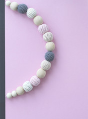 Knitted beads on pink background.