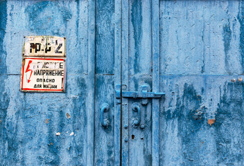 Big industrial metal door with rusty cracked paint