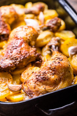 Roasted chicken leg with potatoes with caraway and garlic.