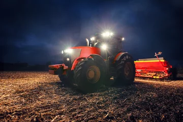 Photo sur Plexiglas Tracteur Tracteur préparant la terre avec le cultivateur de semis la nuit