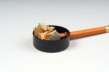 Pencil sharpener shavings on the white paper. Back to school