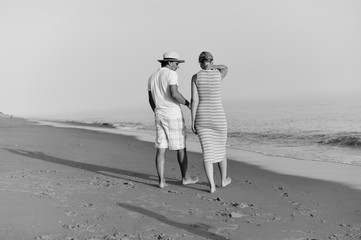 Romantic travel vacation. Joyful male and female couple lovers walking on sand beach sunny background outdoors