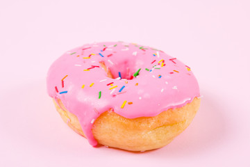 Pink round donut on pastele background. Flat lay, top view.