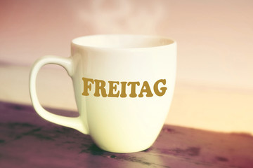 closeup of white cup with the german word Friday