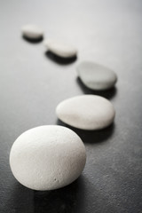 Curving Line of Grey Pebbles on Dark Background