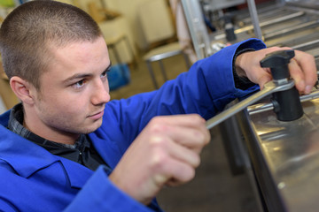 Fototapeta premium Young man using spanner