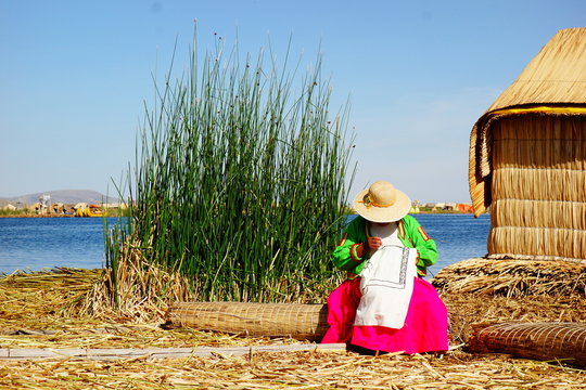 embroidering woman at floating island in peru, titikaka lake