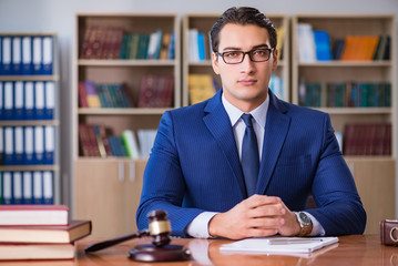 Handsome judge with gavel sitting in courtroom