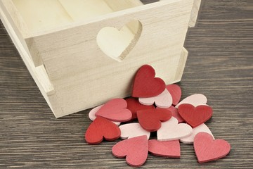 Hintergrund mit roten und rosa Herzen sowie Holzkiste