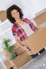 a woman is carrying a heavy cardboard