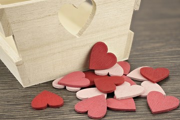 Hintergrund mit roten und rosa Herzen vor Holzkiste