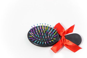 hair comb brush with red bow isolated on white background, gift concept background.