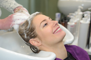Obraz na płótnie Canvas Lady enjoying having hair washed in salon