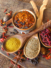 dry Spices, barberry and wooden spoons on a kitchen board