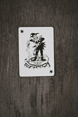 playing cards black joker close up on a wooden table background, space for you text, game risk abstract.
