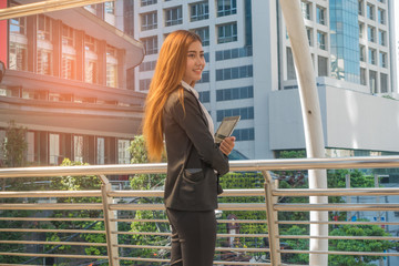 Business woman holding tablet turn to smile happily.