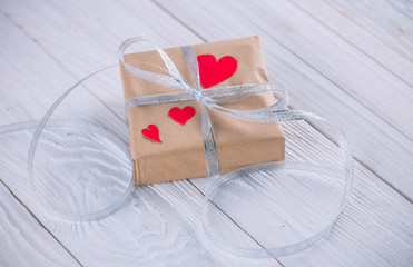 Valentines day gift wrapping on wooden background.