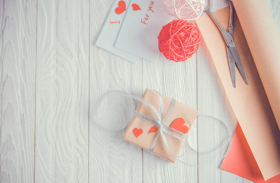 Valentines day gift wrapping on wooden background.