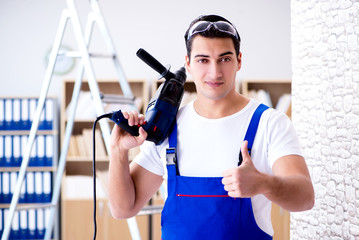 Repairman working with drilling drill perforator