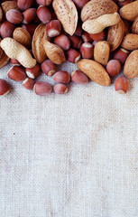 Mixture of nuts almonds peanuts and hazelnuts on a canvas rough canvas.