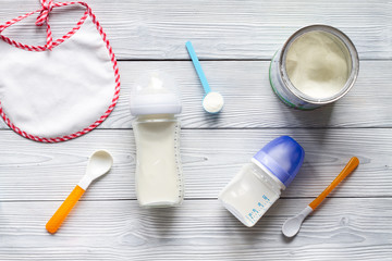 preparation of mixture baby feeding on wooden background top view