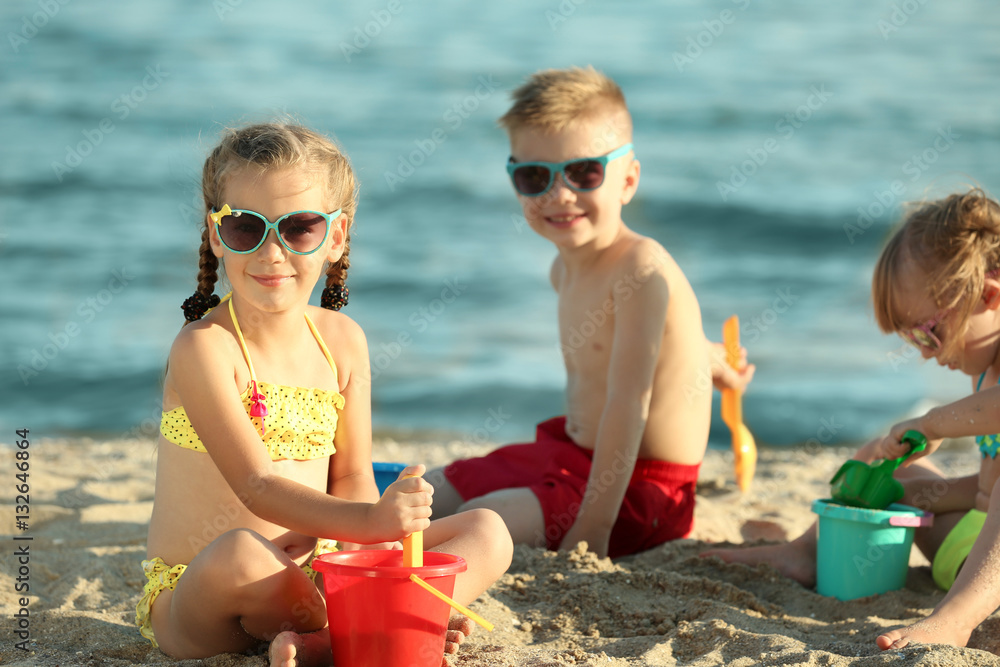 Poster cute kids building sandcastles on beach