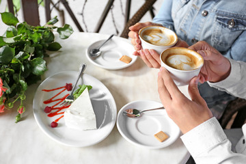 Young couple drinking coffee in cafe, close up view