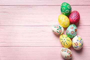 Colourful Easter eggs with floral ornament on pink wooden background