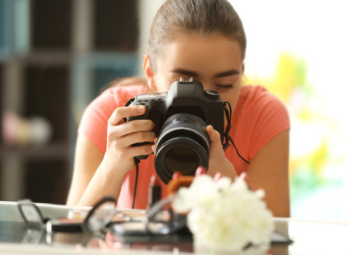 Young woman taking closeup pictures of makeup kit