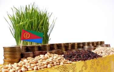Eritrea flag waving with stack of money coins and piles of wheat