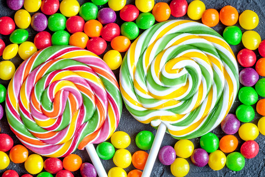 sweets and sugar candies on dark background top view