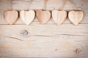 Five wooden hearts on wooden background