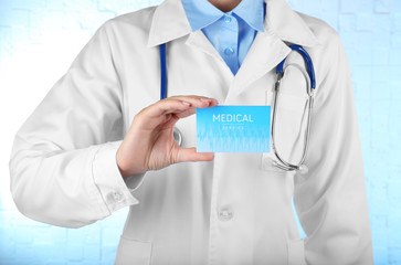 Female doctor holding business card in hand, closeup