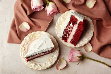 Slices of delicious red velvet cake on table