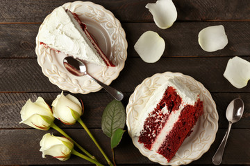 Slices of delicious red velvet cake on table
