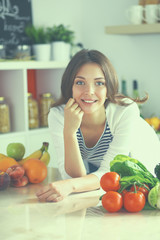 Young woman standing near desk in the kitchen