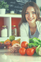 Young woman standing near desk in the kitchen