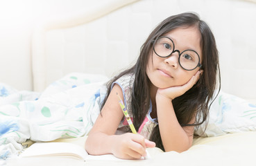 asian girl writing to diary on the bed