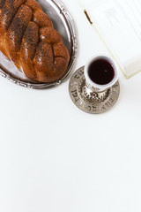 Shabbat shalom, challah with kiddush of wine on a white background. Not isolated, copy space, author processing.