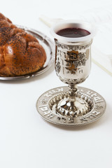 Shabbat shalom, challah with kiddush of wine on a white background. Not isolated, copy space, author processing.
