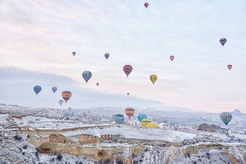Groupe de montgolfières survolant la Cappadoce pendant le lever du soleil en Turquie