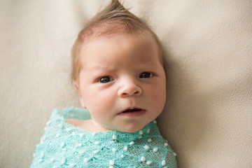 Newborn baby lies on a blanket with hairstyle Mohawk
